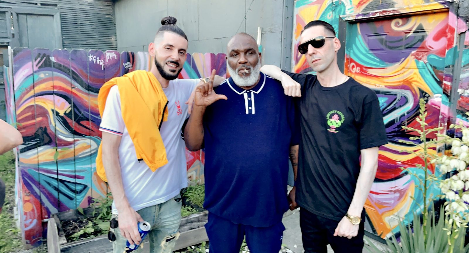 KING T and LUSS with Tojo BiggDawg in front of a colorful mural